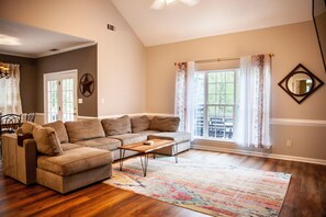 Relax in this inviting living room with a large sofa, coffee table, and area rug.