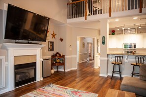 Cozy living area with fireplace, TV, and kitchenette.