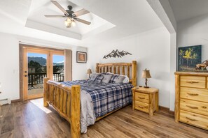 Ein Schlafzimmer mit einem hölzernen Bett, einem Nachttisch, einer Kommode und einem Deckenventilator.