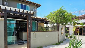 A building with a gated entrance, a small garden, and a clear sky. - Centro UP (Búzios)