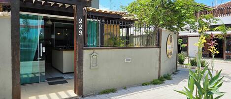 A building with a gated entrance, a small garden, and a clear sky.