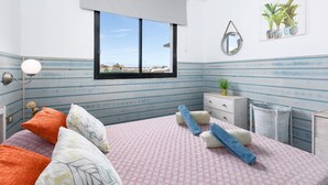 A bedroom with a bed, pillows, a bedside table, a lamp, a window, and a wall-mounted mirror. - Home2Book Cozy Helmut's Place Corralejo, Terrace (Corralejo)