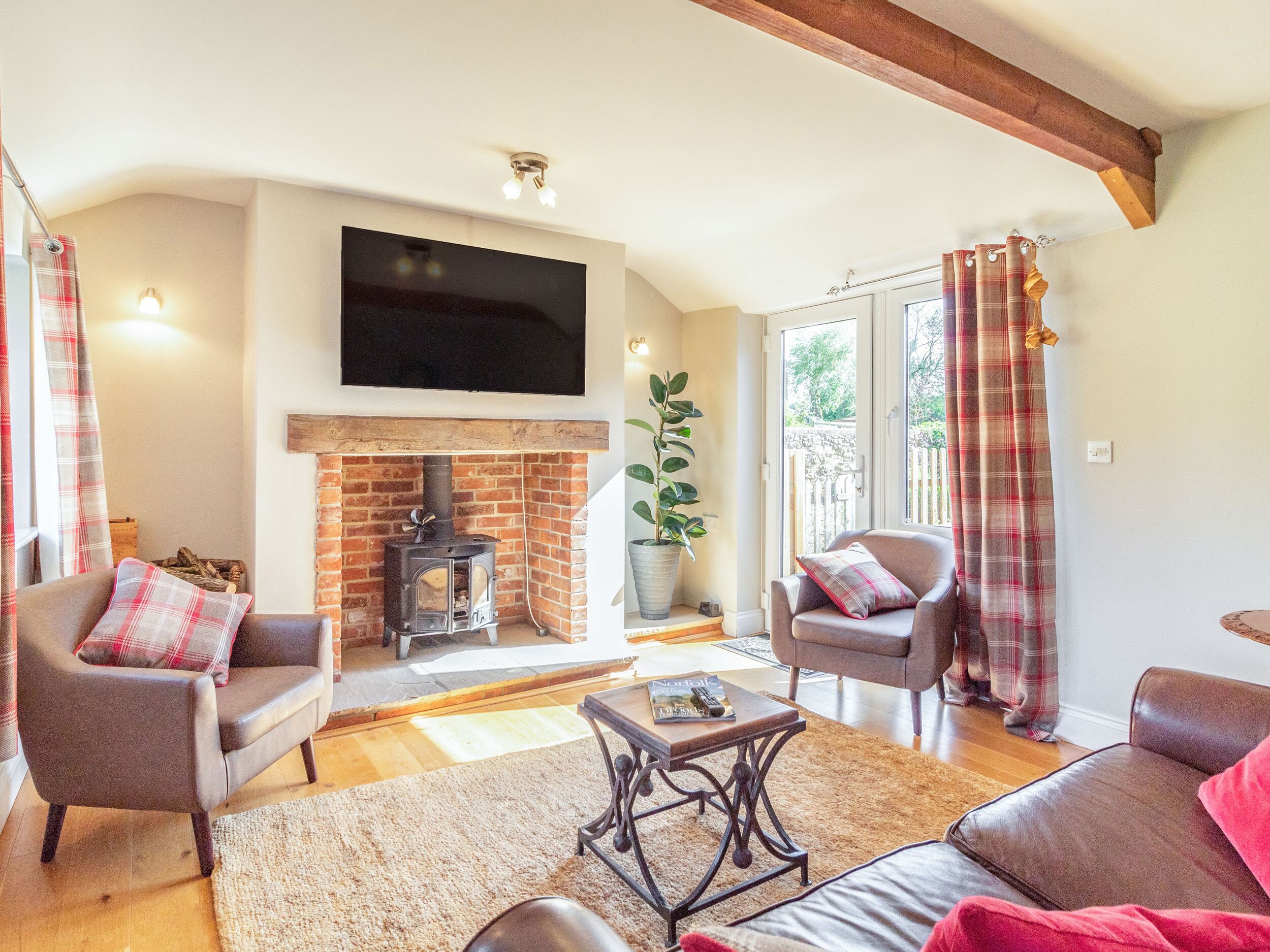 A cozy living room with a fireplace, comfortable seating, and a flat-screen TV.