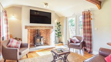 A cozy living room with a fireplace, comfortable seating, and a flat-screen TV.