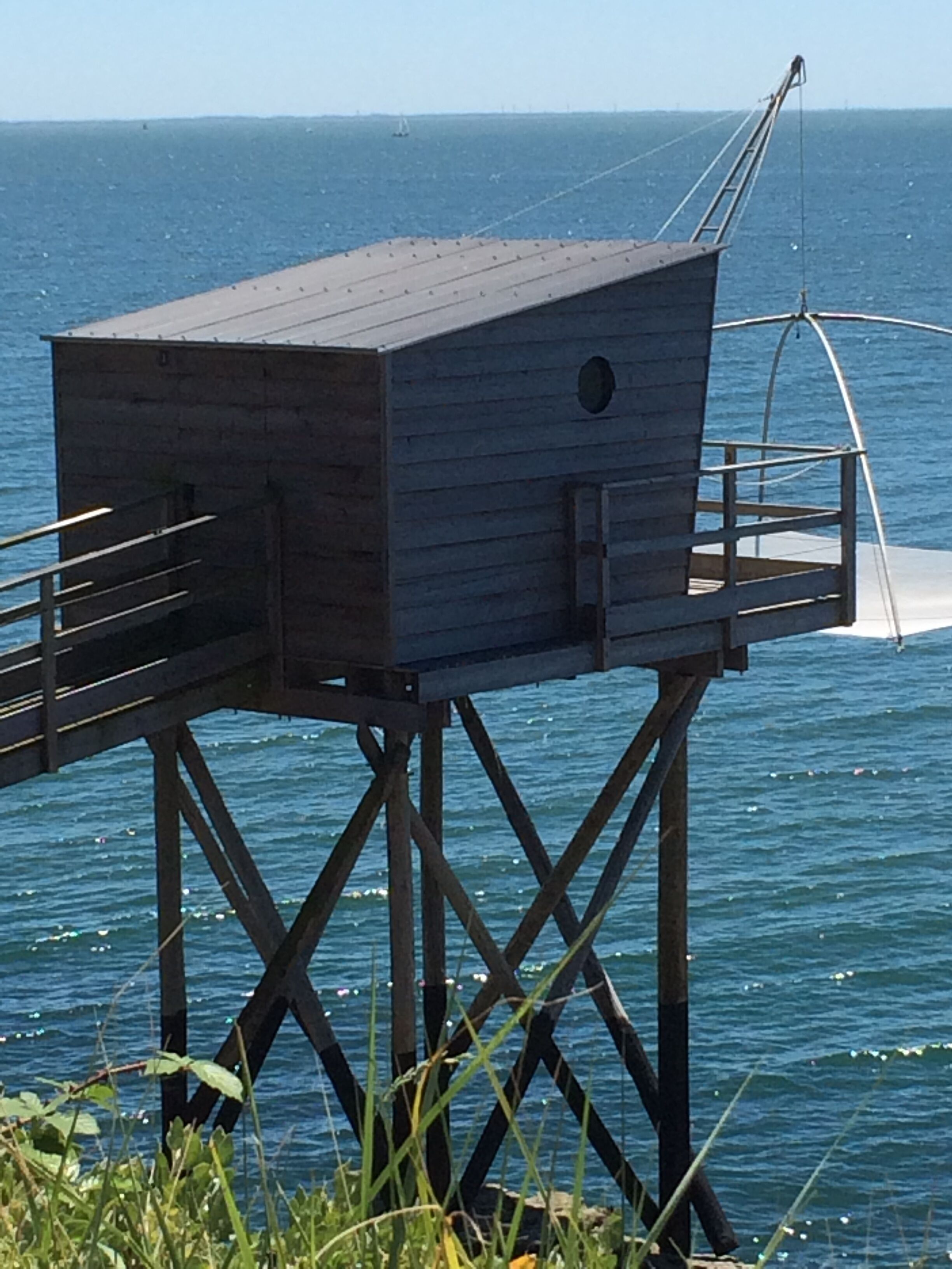 A wooden structure with a platform and railing, overlooking a body of water.