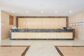 A reception desk with a marble counter, framed certificates on the wall, and a tiled floor. - Tongfa Hot Spring Hotel (Wanning)