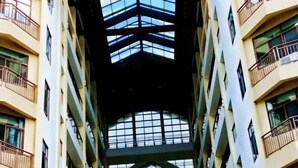 A multi-story building with a central atrium featuring a glass ceiling and balconies on each floor. - Tongfa Hot Spring Hotel (Wanning)