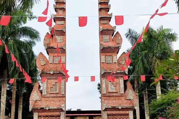 A symmetrical structure with two towers, possibly a temple or gate, surrounded by greenery. - Tongfa Hot Spring Hotel (Wanning)