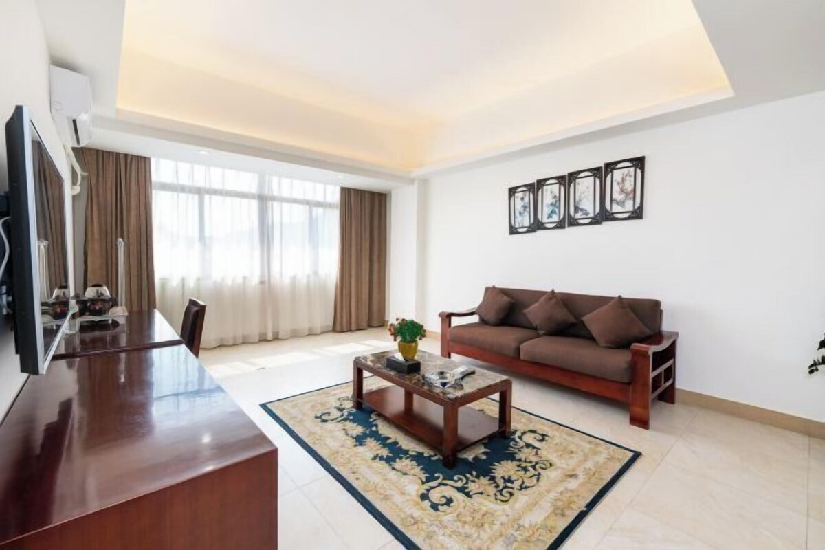 A modern living room with a sofa, coffee table, and artwork on the wall.
