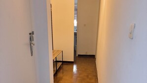 A hallway with a wooden floor, white walls, and a bench. - Apartment rental Propriano (Propriano)
