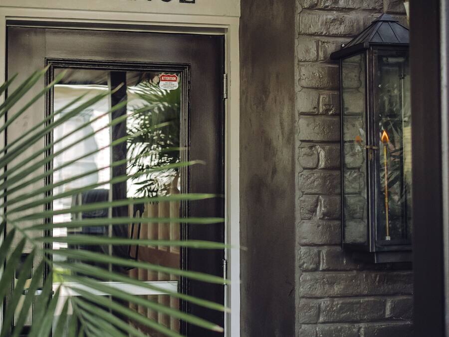 A hotel entrance with a sign, a door, and a lantern.