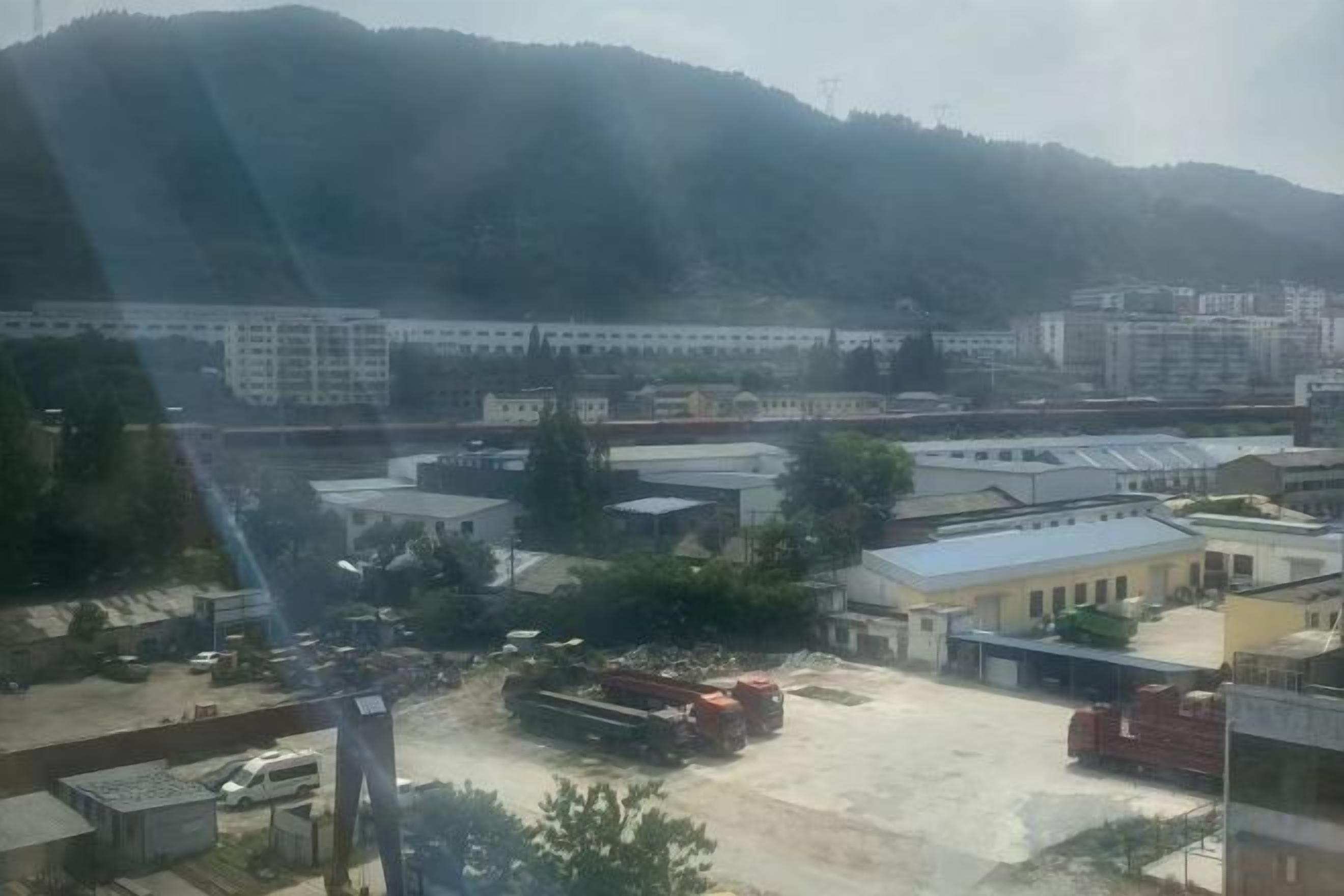 Vista de una obra en construcción con edificios y un amplio espacio abierto.