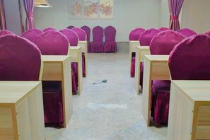 A room with rows of purple chairs and wooden desks, arranged in a classroom-like setting. - Tuke China Light Residence Hotel (Shiyan Wudangshan Airport Branch) (Shiyan)