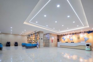 A hotel lobby with a reception desk, seating area, and a bookshelf. - Tuke China Light Residence Hotel (Shiyan Wudangshan Airport Branch) (Shiyan)