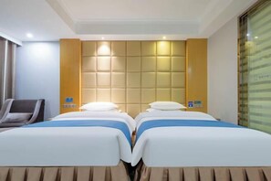 A hotel room with two beds, a massage chair, a large padded headboard, and a window with blinds. - Tuke China Light Residence Hotel (Shiyan Wudangshan Airport Branch) (Shiyan)