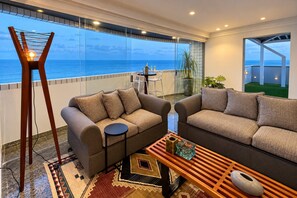 A modern living room with two sofas, a coffee table, and a floor lamp. - Cobertura vista mar com deck privativo (Fortaleza)