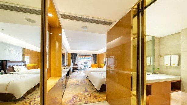 A modern hotel room with two beds, a sitting area, and a bathroom. - the Diamond Hotel (Yanting)
