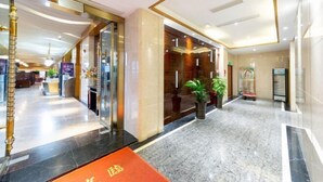 A hotel lobby with a marble floor, a reception desk, and a glass door entrance. - the Diamond Hotel (Yanting)