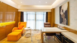 A modern hotel room with a large window, a sofa, a desk, and a painting on the wall. - the Diamond Hotel (Yanting)