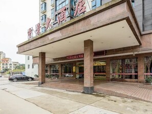 A hotel with a covered entrance, multiple floors, and a visible signboard. - Zhongjing Hotel (Fangchenggang)