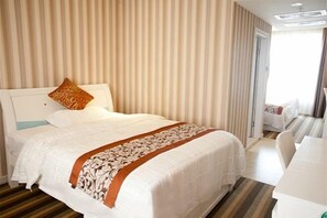 Une chambre d’hôtel avec un grand lit, une table de chevet et une vue sur la chambre voisine.