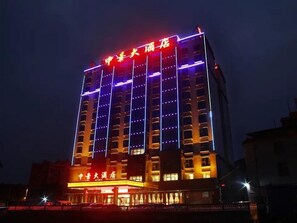 A multi-story hotel building with illuminated signage and windows. - Zhongjing Hotel (Fangchenggang)