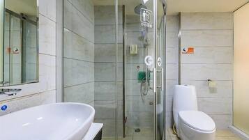 A modern bathroom with a glass-enclosed shower, a white sink, and a toilet.