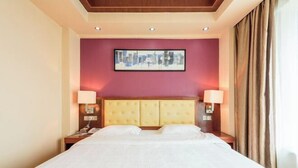 Une chambre d’hôtel avec un grand lit, deux tables de chevet, une tête de lit et une œuvre d’art encadrée au mur.