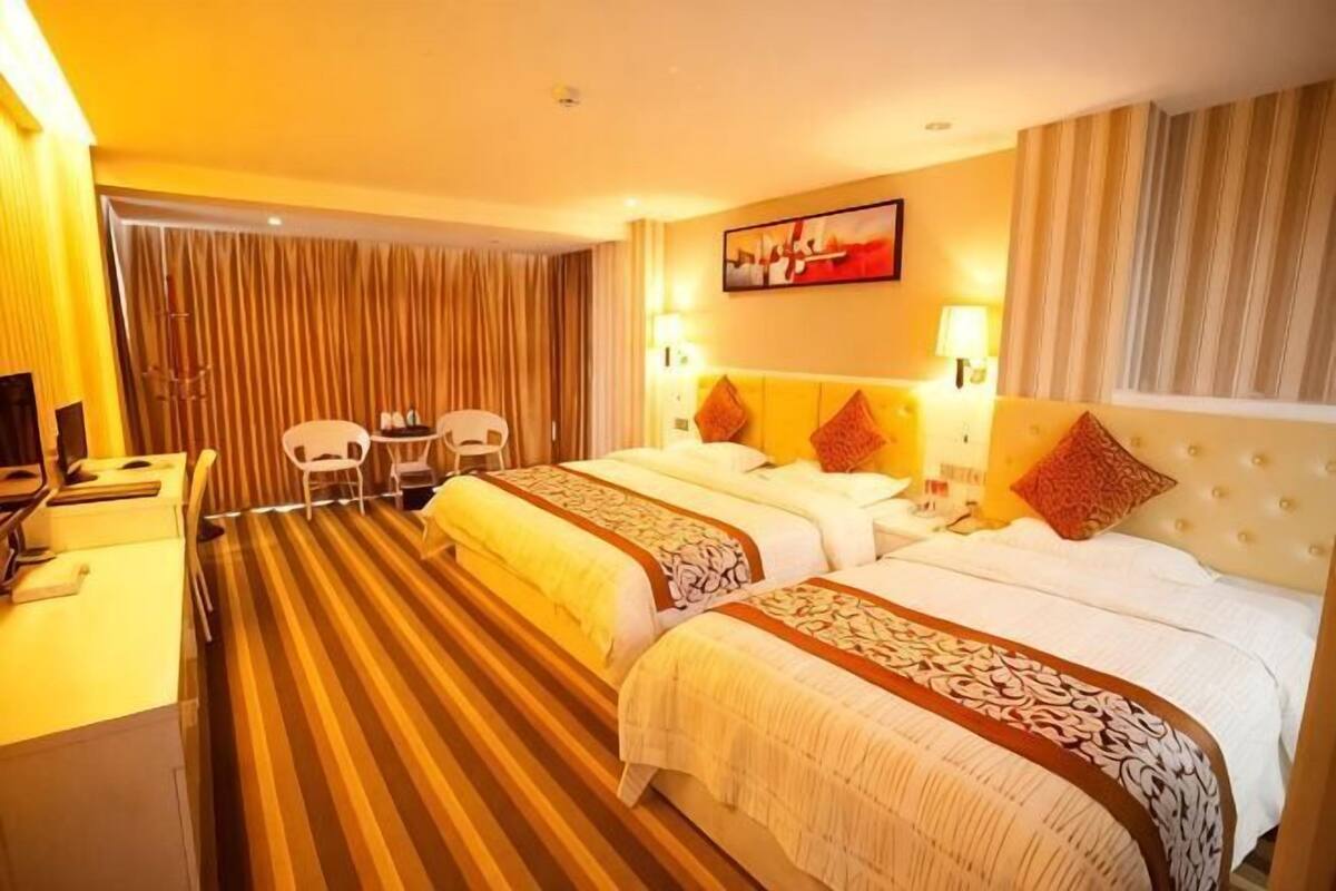 Een hotelkamer met twee bedden, een bureau en een stoel.