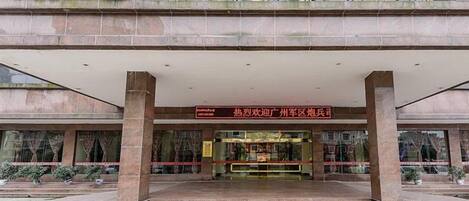 A hotel entrance with a covered walkway, steps leading up to the entrance, and a signboard above.
