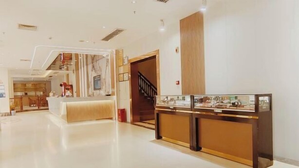A hotel lobby with a reception desk, a staircase, and a dining area. - Zhongjing Hotel (Fangchenggang)