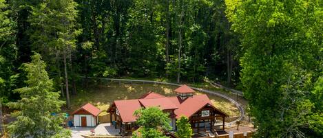 A lodge with multiple cabins, a central building, and a wooden deck with seating.