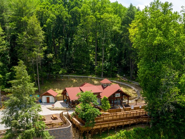 A lodge with multiple cabins, a central building, and a wooden deck with seating.