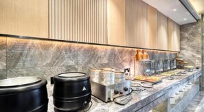 Un buffet avec plusieurs distributeurs de nourriture et un comptoir en marbre.