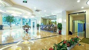 A spacious lobby with a polished marble floor, a reception desk, and potted plants. - Greentree Inn Huzhou Anji Yingbin Avenue Express Hotel (Huzhou)