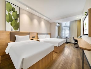 Une chambre d’hôtel avec deux lits, un bureau et une chaise.