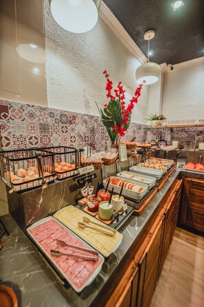 A buffet with various food items and a decorative plant. - Rotorua inn Fortaleza (Fortaleza)