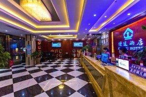 A hotel lobby with a checkered floor, reception desk, and a television screen. - Jiating Hotel (Shenzhen)