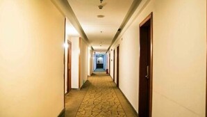 A hotel hallway with carpeted floors and doors on both sides. - Jiating Hotel (Shenzhen)