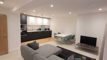 Deluxe Double Room | Living area | 55-inch flat-screen TV with cable channels, TV
