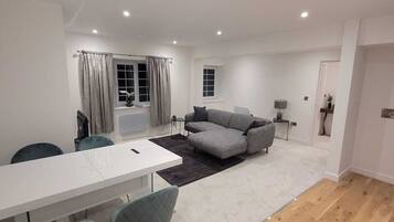 Deluxe Double Room | Living area | 55-inch flat-screen TV with cable channels, TV