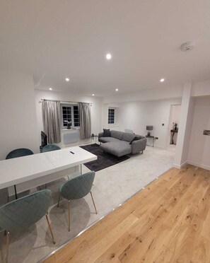 Habitación doble Deluxe | Área de sala de estar | Televisión de pantalla plana de 55 pulgadas con canales por cable 