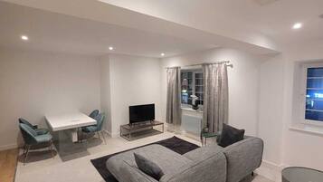 Deluxe Double Room | Living area | 55-inch flat-screen TV with cable channels, TV