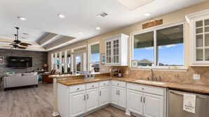 Una cocina moderna con armarios blancos, encimera de granito y una isla grande.