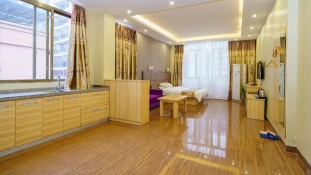 A modern hotel room with a wooden floor, a large window, a bed, a desk, and a wardrobe. - Haiyuewan Holiday Hotel (Fangchenggang)