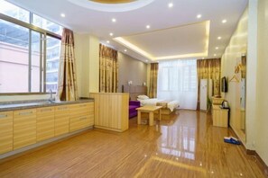 A modern hotel room with a wooden floor, a large window, a bed, a desk, and a wardrobe.