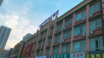 A multi-story building with various commercial establishments on the ground floor, including a restaurant and a store.