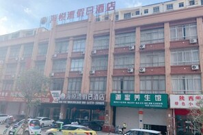 Un edificio de varios pisos con varios establecimientos comerciales en la planta baja.