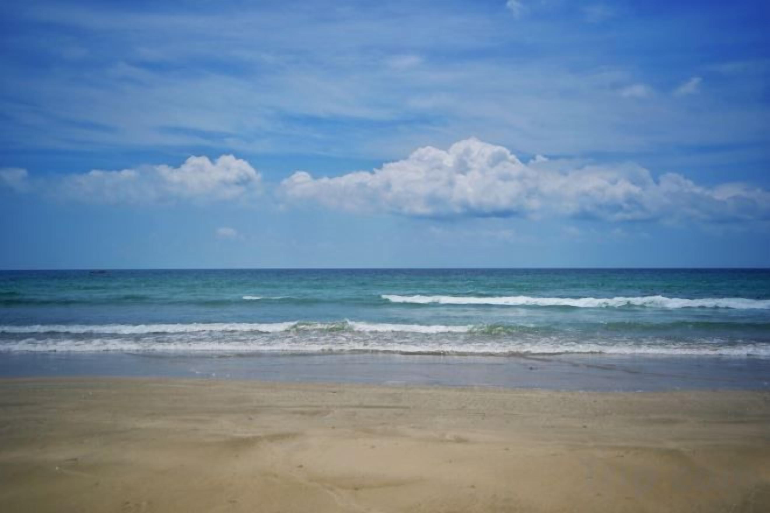 A beach with a clear sky and ocean waves.