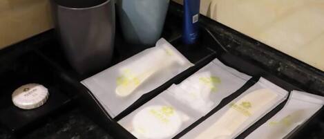 A tray with toiletries including a bottle, two tubes, and a blue packet.